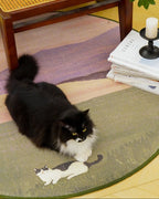 Black cat on a round rug with a 'Hygmeow!' text above, next to a wooden chair and candle.